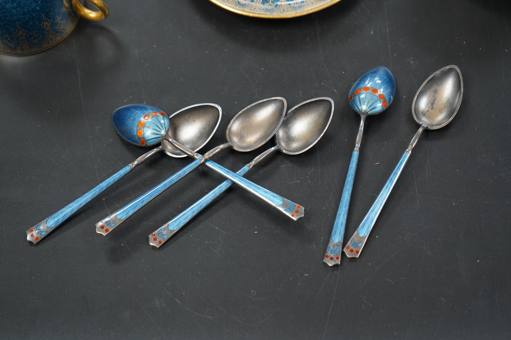 A set of six Royal Worcester cups and saucers, powder blue and gilt decoration, together with a set of six silver and enamel teaspoons